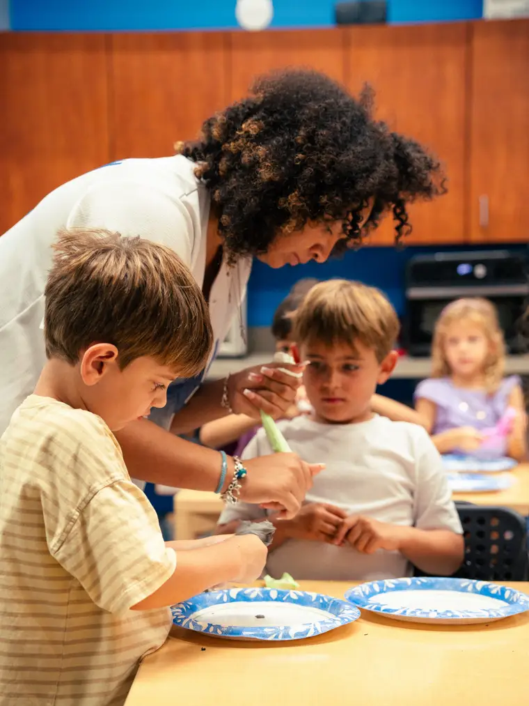 Instructor helping kids with a craft project