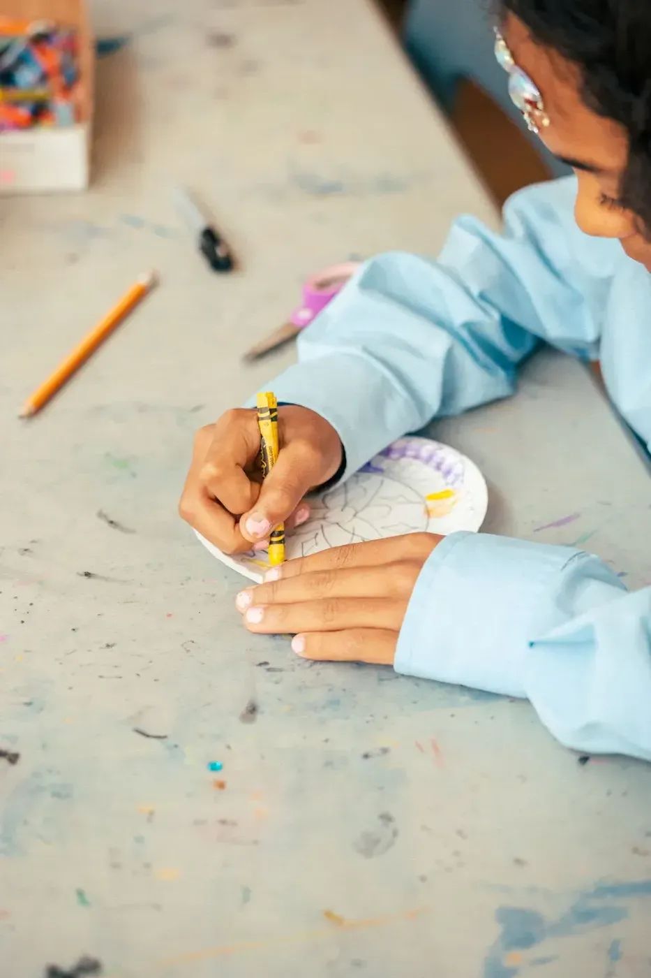 A child working on a craft project at a Recess program